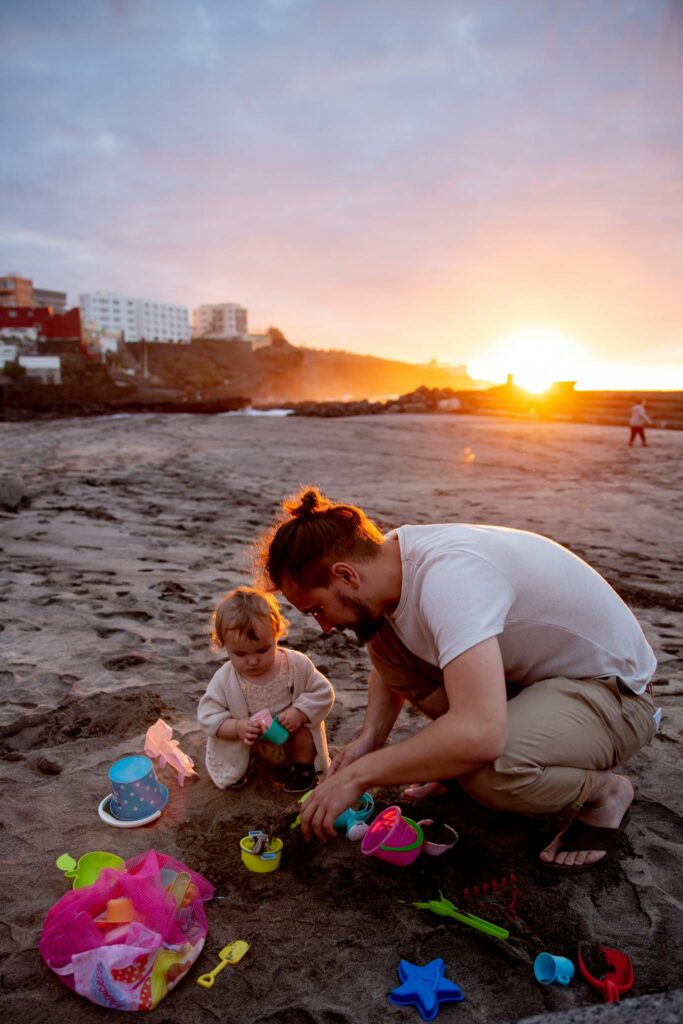 Father and Child Playing on a Sandy Beach at Sunset