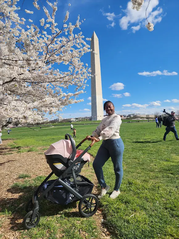 woman and baby in front of the Washington monument during the cherry blossom bloom