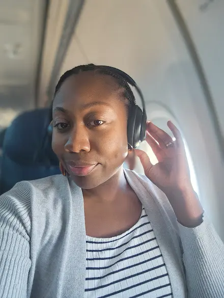 woman listening to music through Beats headphone on a plane