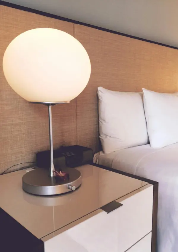 Stylish hotel room featuring soft lighting, elegant bedding, and modern furnishings for a cozy stay.