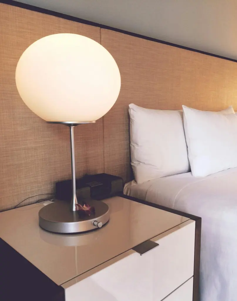 Stylish hotel room featuring soft lighting, elegant bedding, and modern furnishings for a cozy stay.